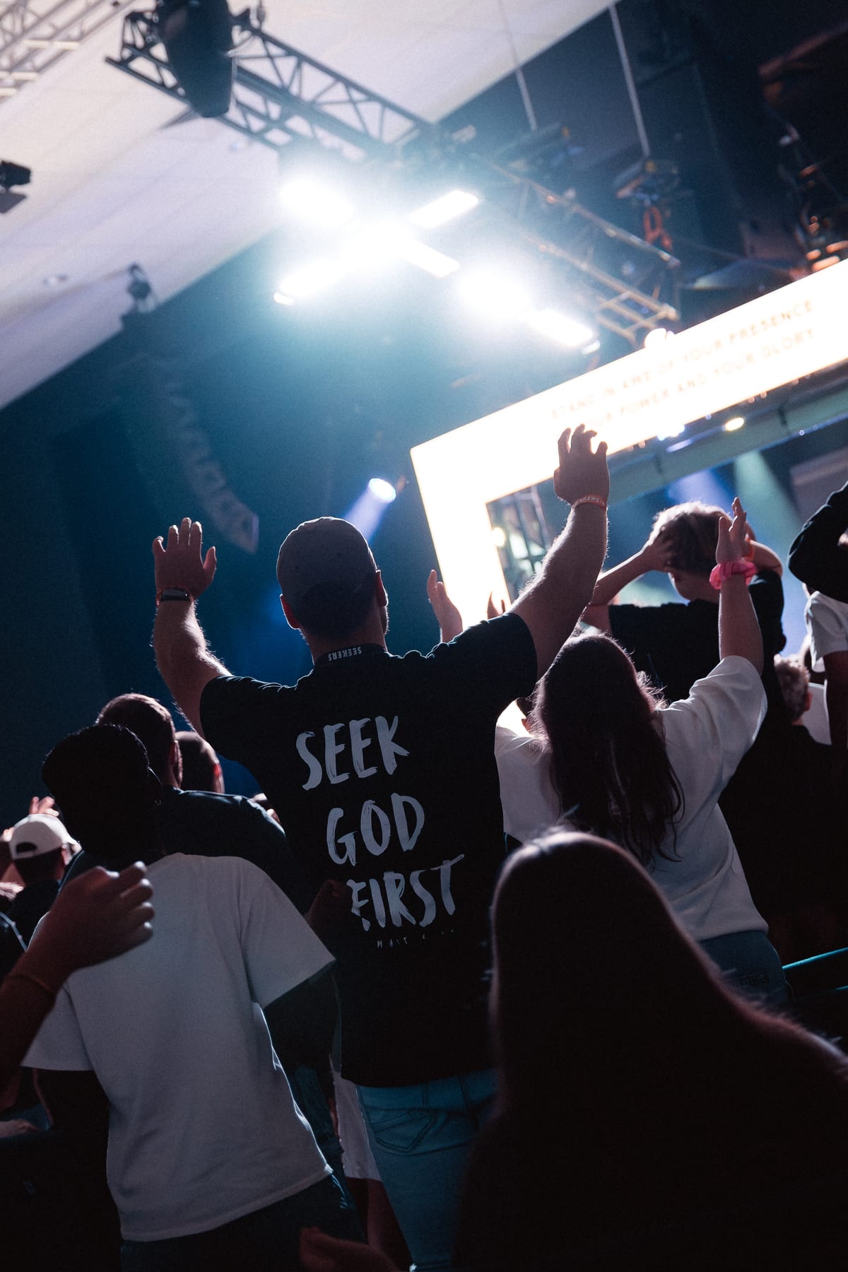 Young people worshipping with hands raised at Seekers